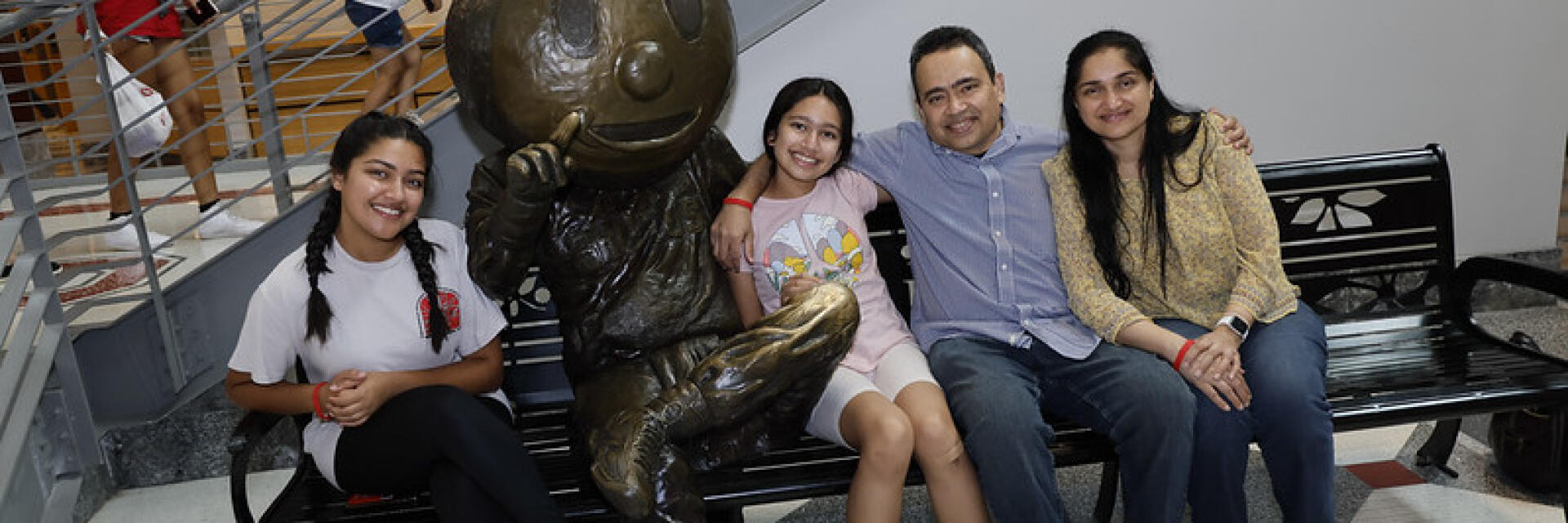 A family takes a picture with Bronze Brutus in the Ohio Union during Parent and Family Weekend 2022