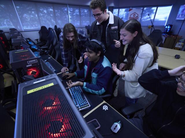 Students interact with a desktop computer at the Esports Arena