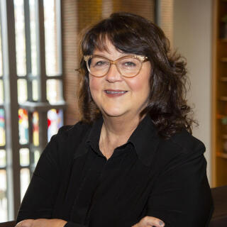 Beth Ullum standing in the Ohio Union with the West Plaza windows in the background