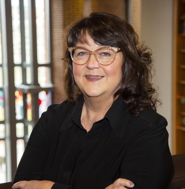 Beth Ullum standing in the Ohio Union with the West Plaza windows in the background
