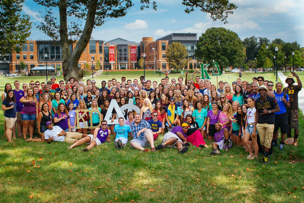 Members of sororities and fraternities stand on the South Oval with the Ohio Union in the background