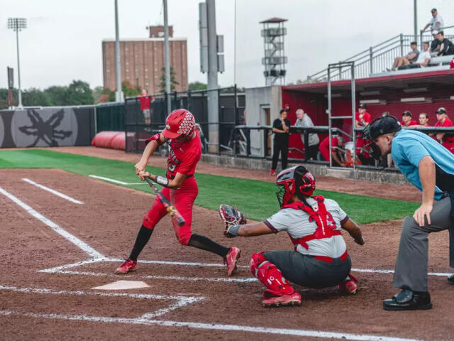 An Ohio State softball player swings at a pitch during a game