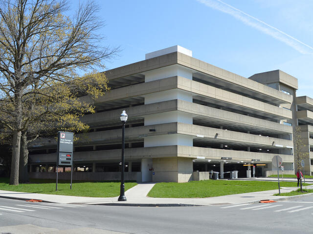 A person walking through a crosswalk on W Woodruff Avenue in front of the Arps Garage