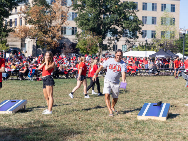 A Buckeye dad plays cornhole at Buckeye Family Tailgate 2025