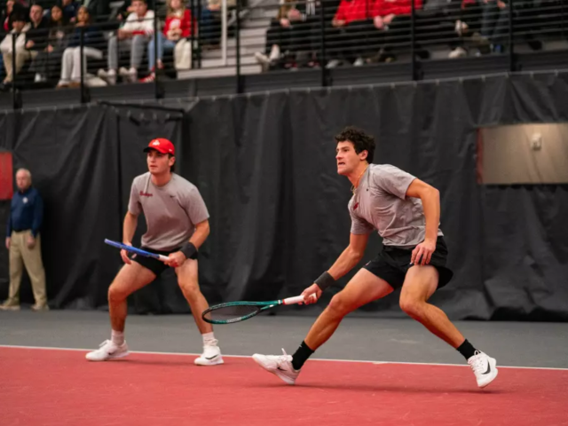 Two men's tennis players in position during a doubles match